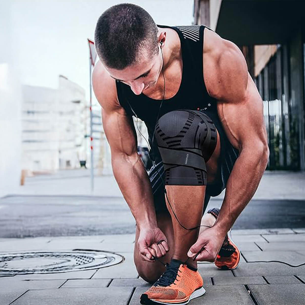 Athletic man tying shoe while wearing Saniflex Aktiv-Kniebandage for knee support during workout.
