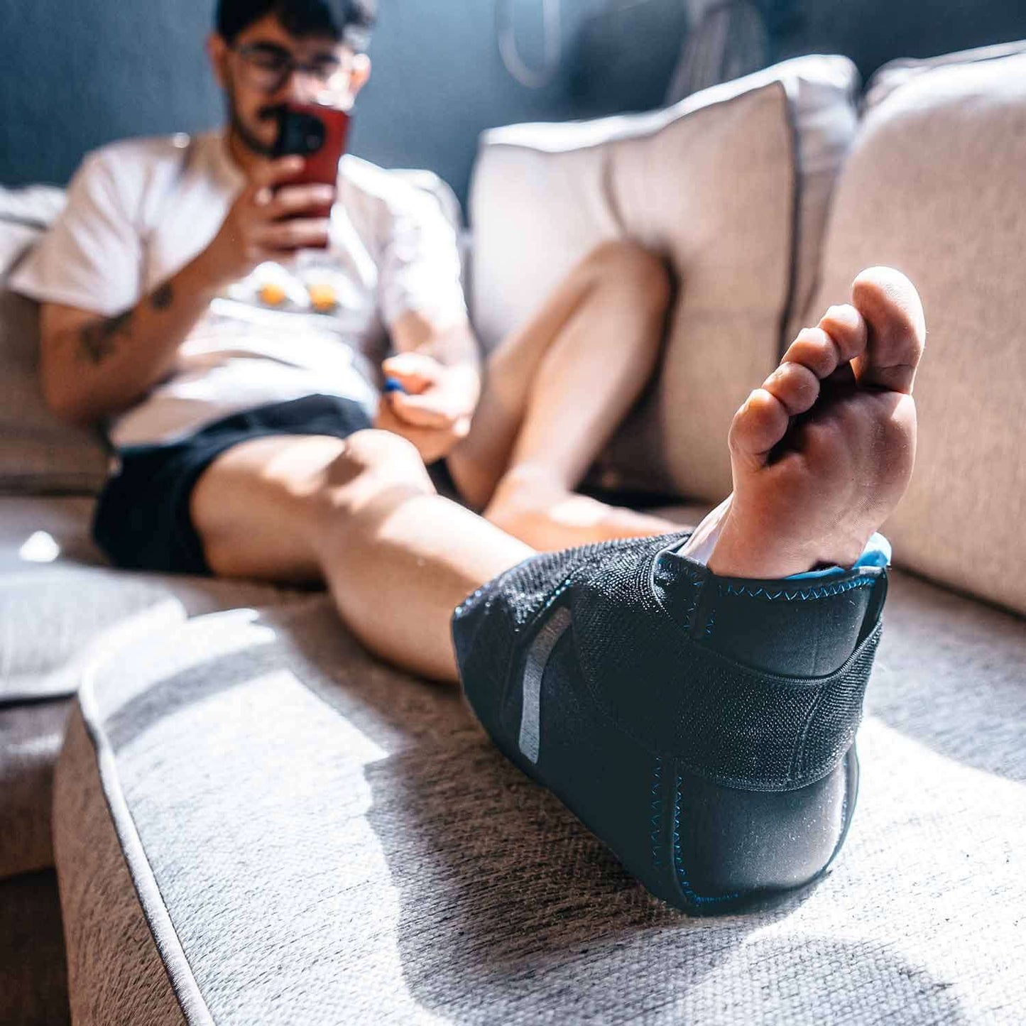 Saniflex ChillWrap foot bandage on a person's foot while relaxing at home, providing comfort and support.