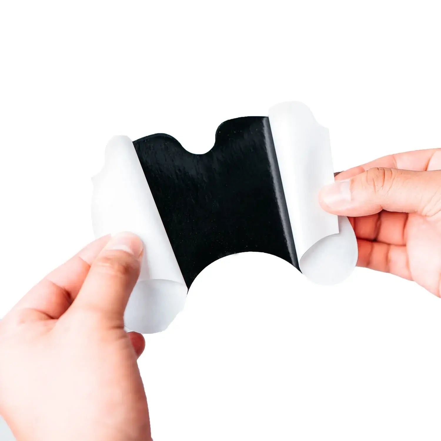 Hands holding a SaniFlex Schmerzpflaster, showcasing its adhesive side ready for application.
